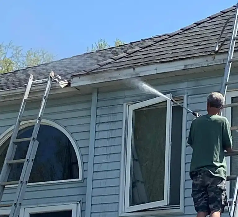 technician clearing debris during an eavestrough maintenance visit technician clearing debris during an eavestrough maintenance visit
